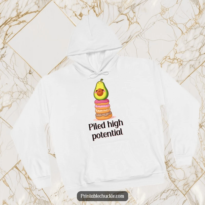 Funny hoodie showcasing a determined avocado struggling to maintain balance on a towering, wobbly stack of donuts, a humorous scene.