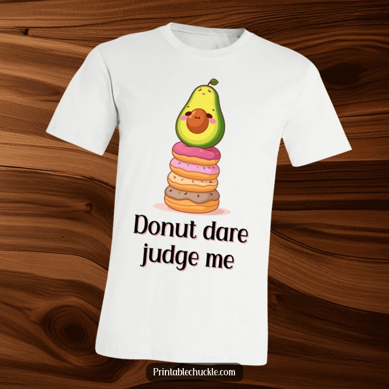 Funny t-shirt depicting a determined avocado attempting to balance atop a precarious stack of donuts, illustrating a funny, challenging feat.